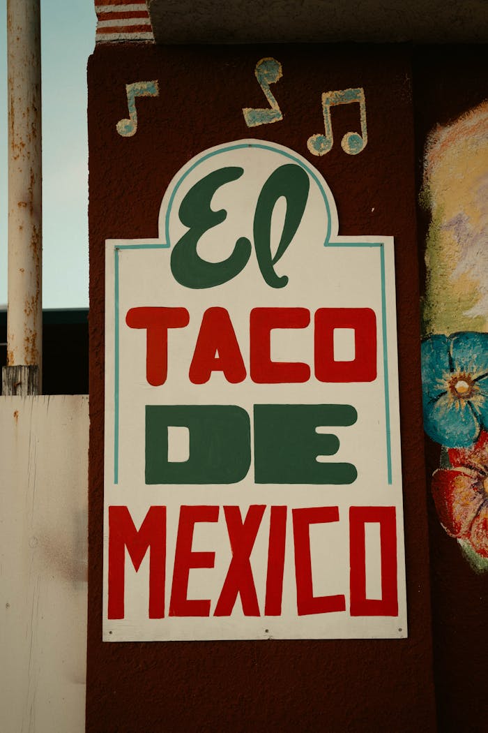 Vibrant sign reading El Taco De Mexico with musical notes adds charm to an exterior wall.